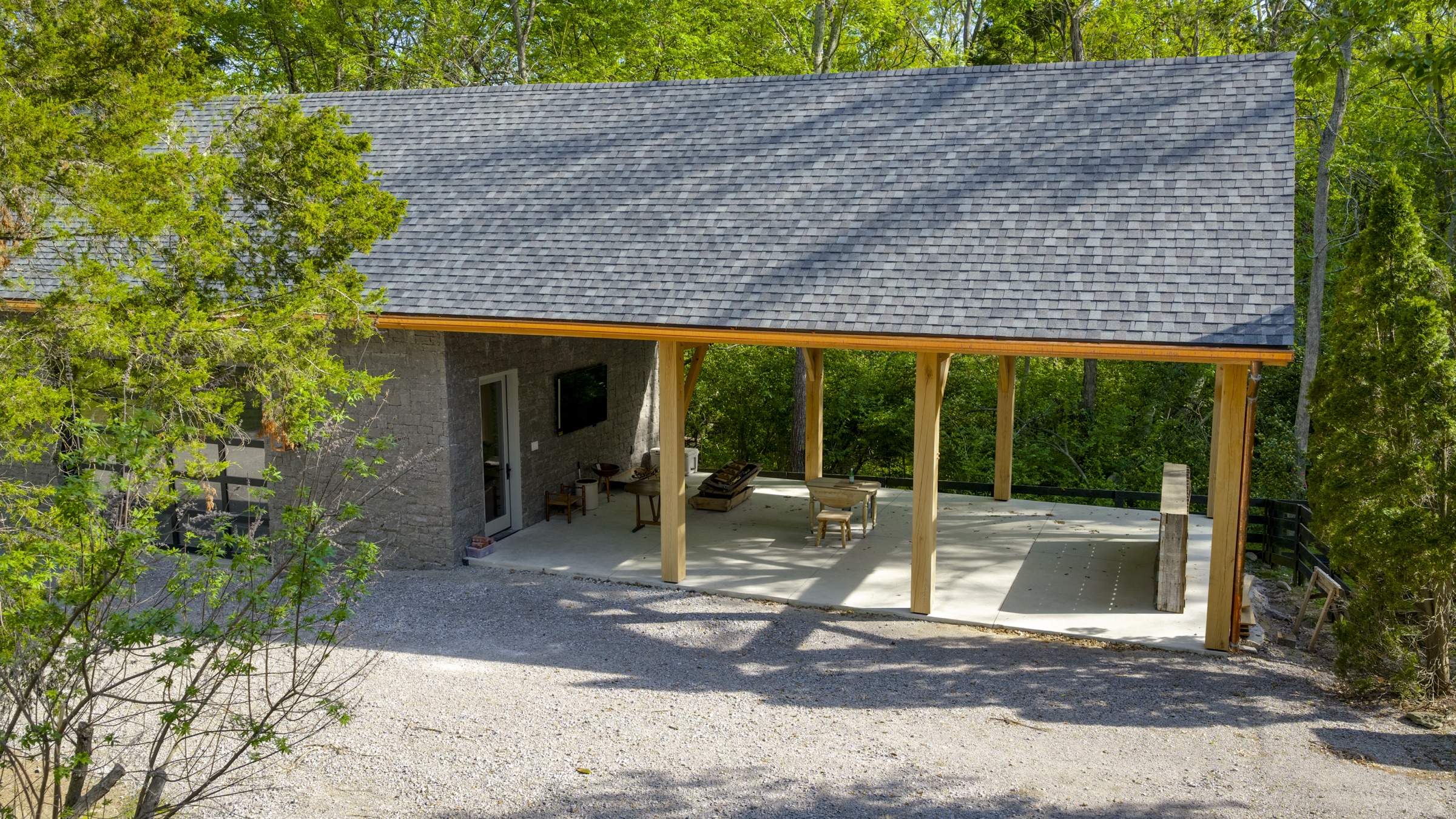 Aerial view of timber frame roof and gray stone wall during construction