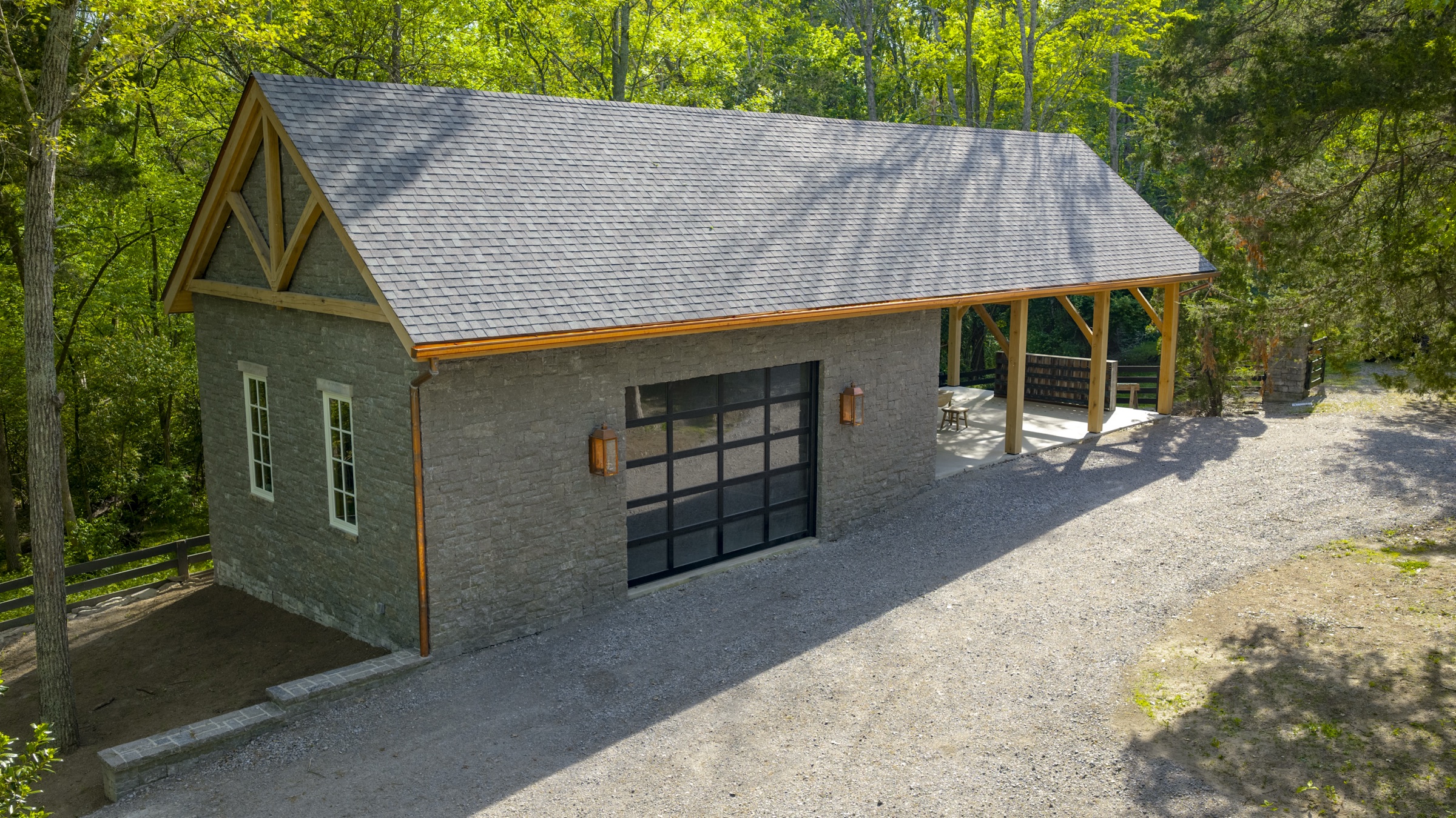 Finished gray stone and timber frame workshop with open bay and gabled roof