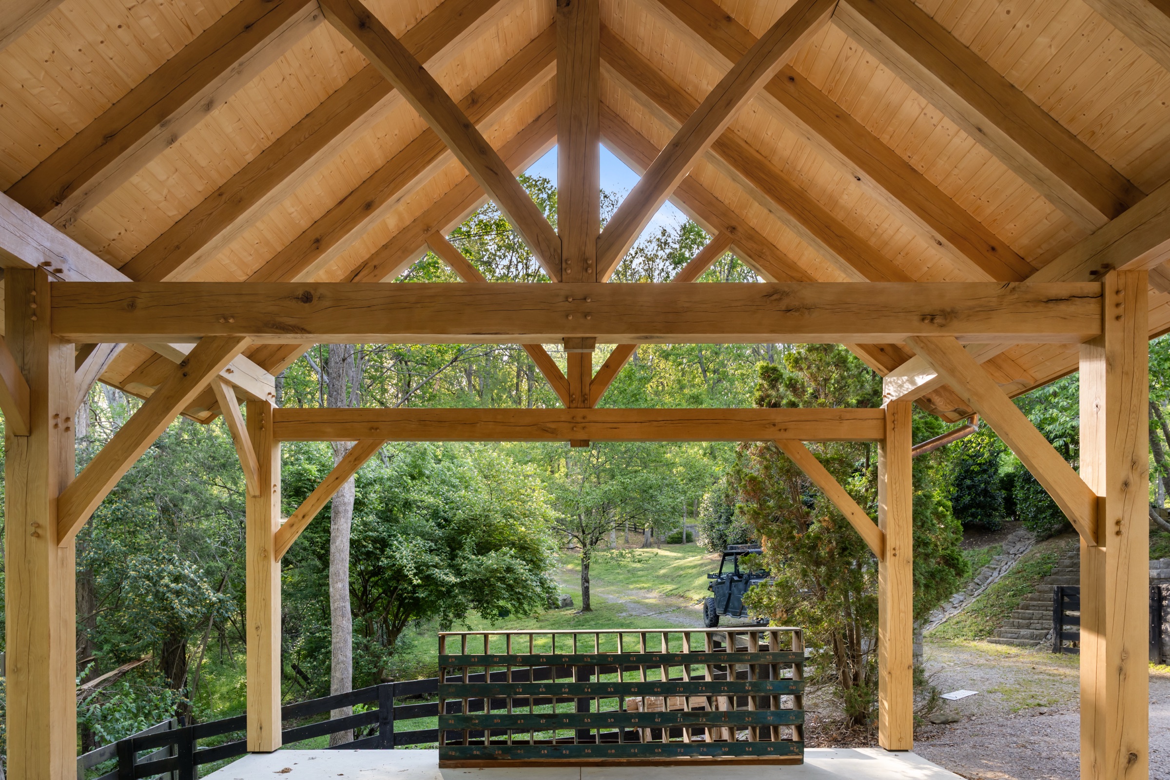 Wide interior view of timber trusses and stone wall