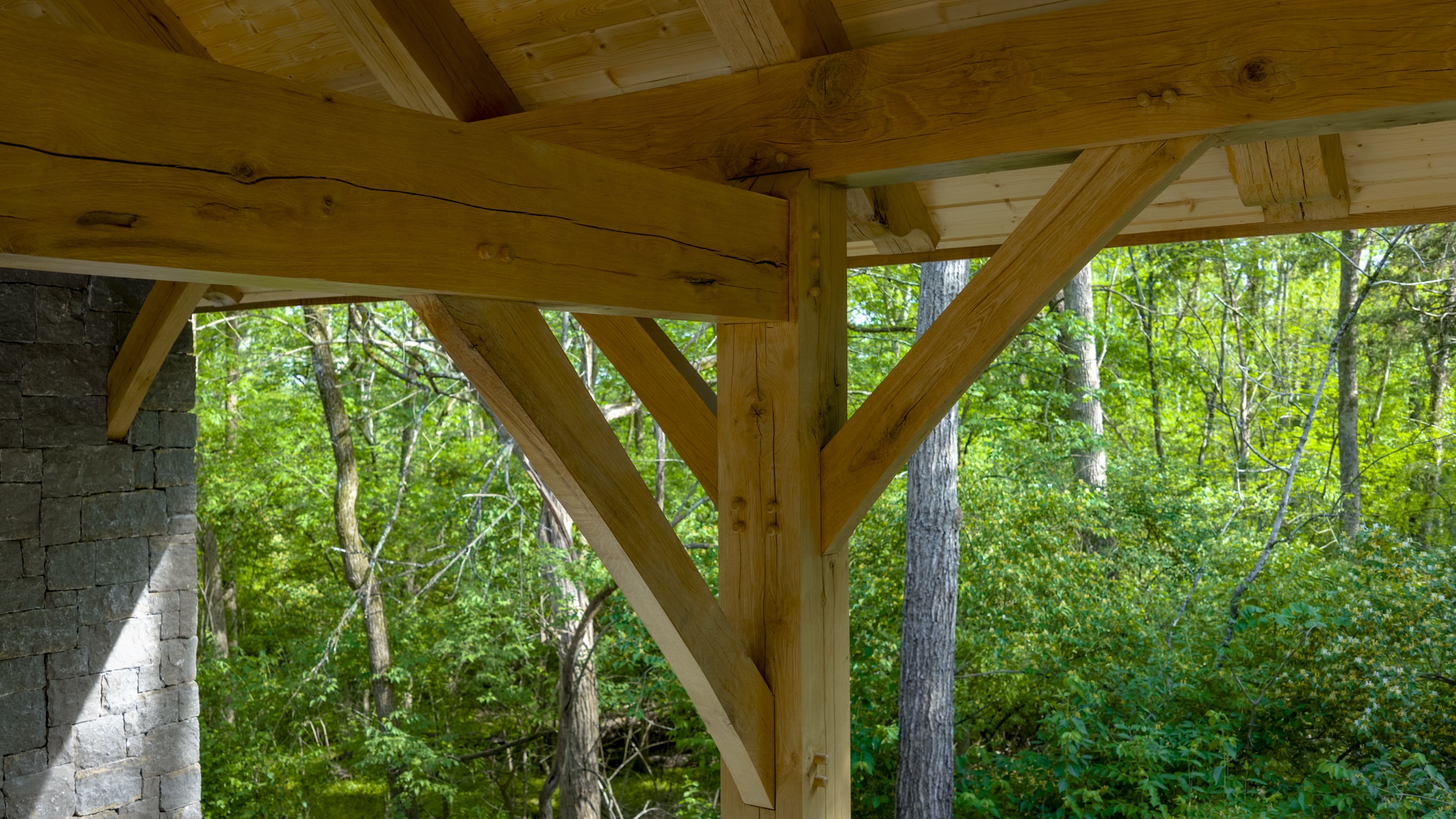 Gray stone masonry wall meeting timber frame posts