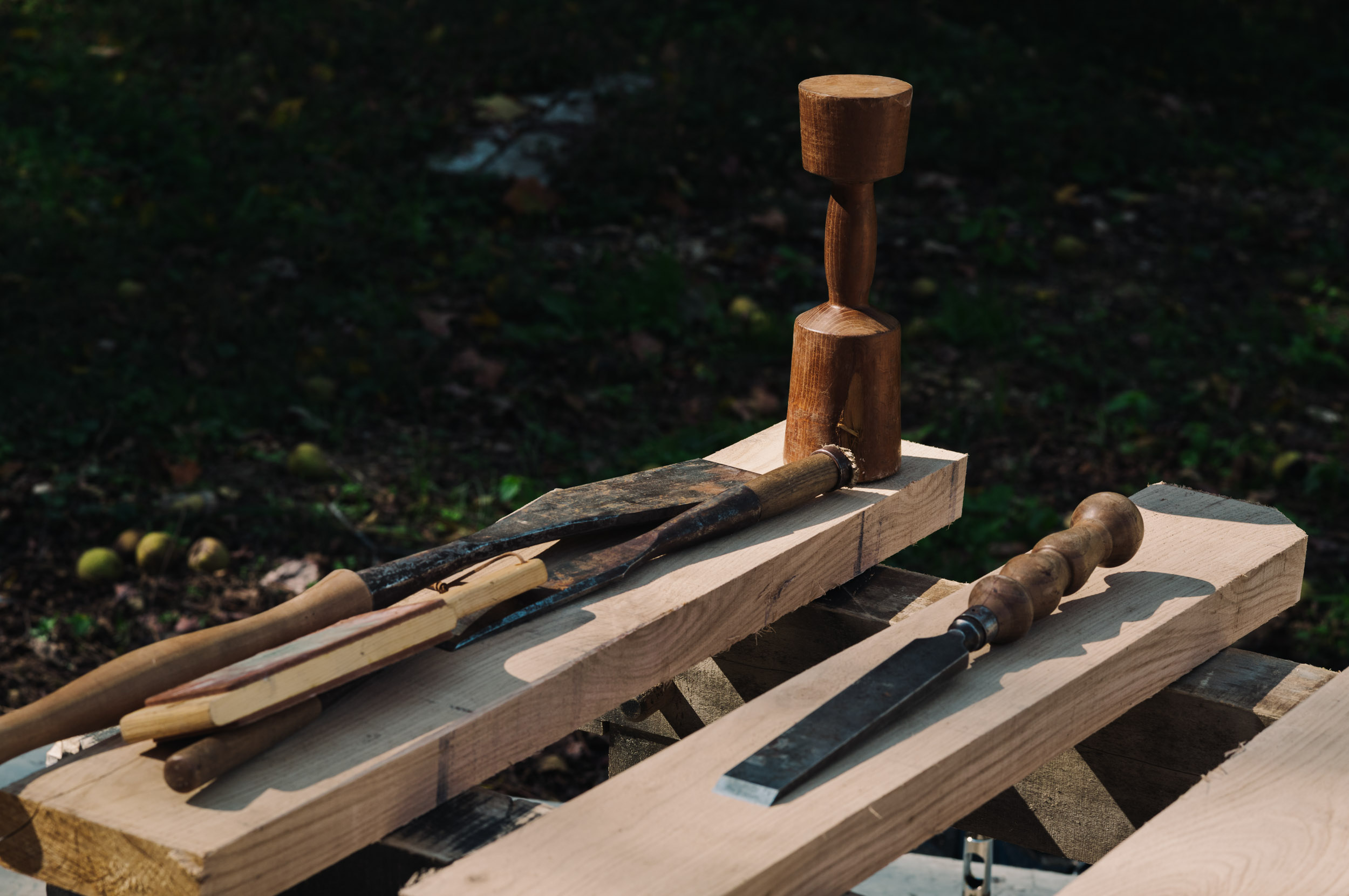 Traditional woodworking tools resting on lumber outdoors